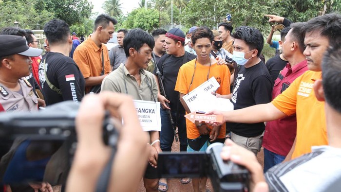 Tersangka Erwinudin memperagakan adegan dalam rekonstruksi kasus pembunuhan 4 keluarganya yang jasadnya dibuang ke dalam Septic Tank di Desa Marga Jaya, Kecamatan Negera Batin, Kabupaten Way Kanan, Lampung,  Jumat (8/10/2022). Foto Tommy Saputra/detikSumut