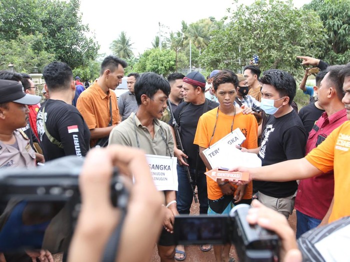Tersangka Erwinudin memperagakan adegan dalam rekonstruksi kasus pembunuhan 4 keluarganya yang jasadnya dibuang ke dalam Septic Tank di Desa Marga Jaya, Kecamatan Negera Batin, Kabupaten Way Kanan, Lampung,  Jum'at (8/10/2022). Foto Tommy Saputra/detikSumut