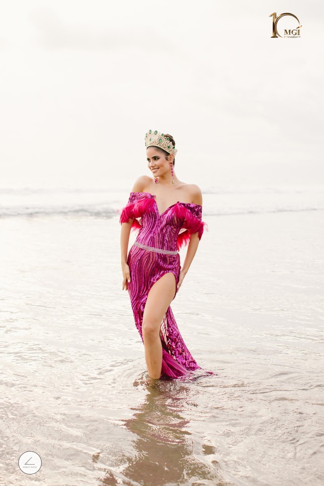 Cantiknya Miss Grand Spanyol 2022 Hirisley Jimenez saat berpose bertelanjang kaki dan membiarkan gaun glamournya terkena ombak Pantai Seminyak. Foto: Dok Yayasan Dunia Mega Bintang