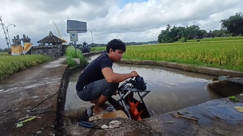 I Made Agus Permana Dwiputra dengan PLTMH yang dibuat bersama teman sekelasnya, I Gede Gunem Kusuma Wijaya, telah berhasil diujicoba di saluran irigasi Desa Bengkel, Kecamatan Kediri.