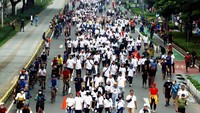 Para peserta melintas di antara warga yang melakukan aktivitas olahraga di kawasan car free day.