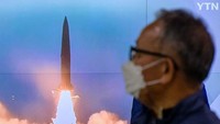 Seorang warga menyaksikan peluncuran rudal Korea Utara yang ditayangkan di televisi.