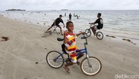 Tua, muda dan anak-anak tampak menikmati waktu bersama di Pantai Weluan yang indah. 