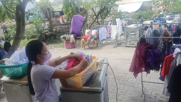 Pada Minggu (9/10/2022), Pemilik laundry Dandi, Ketut Arianti (38) tampak tengah menjemur beberapa pakaian pasca kejadian banjir di Jalan Pura Demak Gang I Denpasar, Bali