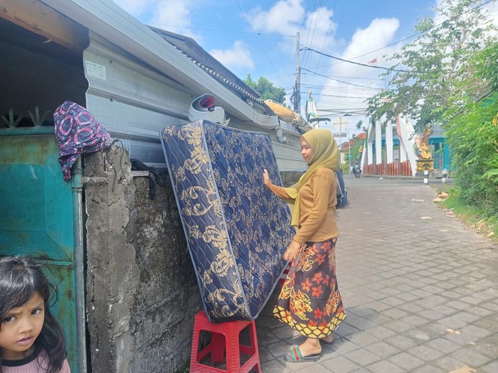 Pasca banjir nampak warga menjemur kasurnya yang masih basah di Tukad Mati, Legian, Minggu (9/10/2022).