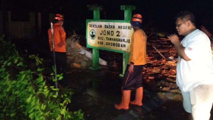 Petugas melakukan evakuasi pohon tumbang di sekolah Dasar Negeri 2 Jono, Desa Jono, Kecamatan Penawangan, Kabupaten Grobogan, Minggu (9/10/2022).