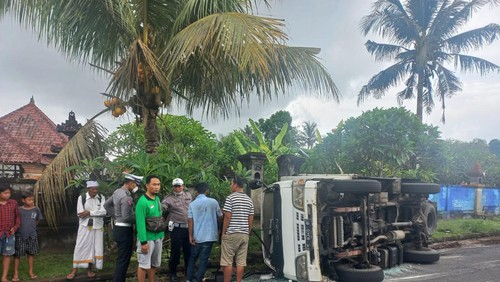 Mobil truk boks Isuzu DK 8346 OQ terguling di jalan umum Banjar Penida, Desa Batuan, Kecamatan Sukawati, Kabupaten Gianyar.