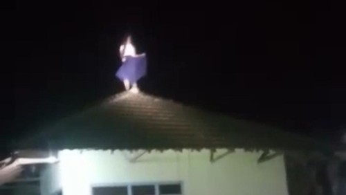 Wanita yang naik ke atap rumah warga lalu tertawa terbahak-bahak