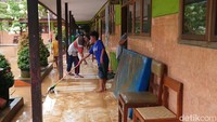 Guru, siswa dan wali murid bergotong royong membersihkan SDN 1 Tasikmadu dari material banjir/Foto: Adhar Muttaqin/detikJatim