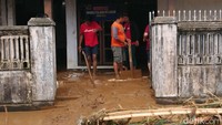 Warga membersihkan rumah dari lumpur sisa banjir/Foto: Adhar Muttaqin/detikJatim