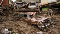 Sebuah mobil rusak parah setelah diterjang material longsor.