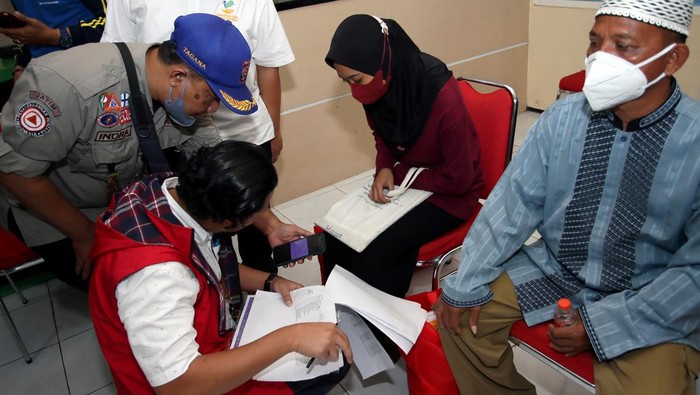 Detik-detik Keluarga Korban Tragedi Kanjuruhan Pingsan Usai Terima Bansos Menko PMK Muhadjir Effendi (kanan) menyerahkan bansos kepada keluarga korban meninggal tragedi Kanjuruhan di Kantor Kecamatan Lowokwaru, Kota Malang, Jawa Timur, Senin (3/10/2022). Mensos Tri Rismaharini bersama Menko PMK Muhadjir Effendi dan Wakil Ketua MPR Ahmad Basarah menyampaikan belasungkawa sekaligus menyerahkan secara langsung bansos berupa uang tunai dan sembako kepada sejumlah keluarga korban tragedi Kanjuruhan di wilayah tersebut. ANTARA FOTO/Irfan Anshori/rwa.