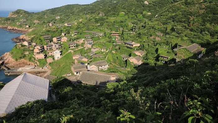 ZHOUSHAN, CHINA - MAY 20: Houses covered with tendril climbing plants are seen at the deserted Houtouwan village on Shengshan island on May 20, 2020 in Zhoushan, Zhejiang Province of China. The village in East China has become a tourist spot for its natural ecology and fine views. (Photo by Chen Yongjian/VCG via Getty Images)