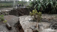 Warga melihat jembatan yang ambrol diterjang banjir bandang di Desa Pekuncen, Pekuncen, Banyumas, Jateng, Senin (10/10/2022).   