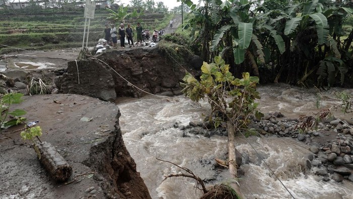 Jembatan di Banyumas Ambruk Tergerus Banjir Warga melihat jembatan yang ambrol diterjang banjir bandang di Desa Pekuncen, Pekuncen, Banyumas, Jateng, Senin (10/10/2022). Sebuah jembatan penghubung Desa Pekuncen dan Glempang putus terbawa arus.
