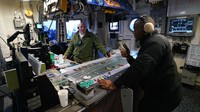 Petugas kontrol udara bekerja di ruang kontrol kapal induk bertenaga nuklir USS Gerald R. Ford di lepas pantai Virginia, Rabu (5/10/2022). Usai dirancang lebih dari 40 tahun, kapal induk ini mulai diproduksi pada November 2009 dan dirilis ke publik pada 2017 oleh mantan Presiden Donald Trump.   