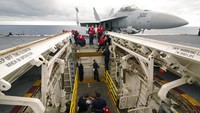 Personel senjata bekerja di dek kapal induk USS Gerald R. Ford di lepas pantai Virginia, Rabu (5/10/2022). Armada ini menggunakan sistem peluncuran pesawat elektromagnetik (EMALS), bukan dengan sistem ketapel uap konvensional. Efeknya, mengurangi tekanan pada pesawat dan waktu yang lebih singkat di setiap peluncuran.  