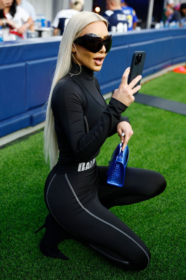 Kim Kardashian memilih tampilan yang beda dari kebanyakan orang saat menonton pertandingan football. Jika biasanya pilihan busana orang pada umumnya adalah sporty atau casual, Kim mengenakan catsuit. Foto: Getty Images