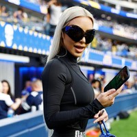 Istri Kanye West itu memakai busana dan aksesori serba Balenciaga saat menonton football. Catsuit yang dipakainya datang dari Balenciaga. Foto: Getty Images