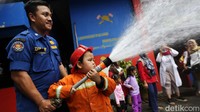Anak-anak itu juga mempraktekkan cara menyemprotkan air ke lokasi yang diibaratkan sebagai titik kebakaran.