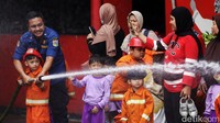 Dengan mengenakan pakaian Damkar, anak-anak itu berkesempatan merasakan pengalaman menjadi petuga pemadam kebakaran.