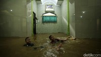 Banjir dimanfaatkan oleh anak-anak untuk bermain air.