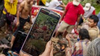 Kerabat mengabadikan proses mengganti pakaian jenazah keluarganya saat ritual Manene di Lembang Ampang Batu, Kabupaten Toraja Utara, Sulawesi Selatan. Mereka melakukan musyawarah keluarga besar sebelum memulai ritual Ma’nene. Sebuah tradisi animisme yang masih dipertahankan oleh masyarakat suku Toraja hingga saat ini.  