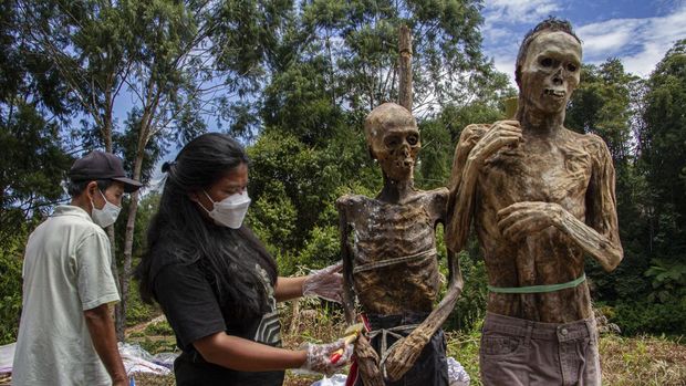 Kerabat membersihkan jenazah keluarganya saat ritual Manene di Lembang Ampang Batu, Kabupaten Toraja Utara, Sulawesi Selatan.