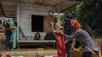 Sejumlah kerabat melakukan proses mengganti pakaian jenazah keluarganya saat ritual Manene di Lembang Ampang Batu, Kabupaten Toraja Utara, Sulawesi Selatan. Lalu jenazah disimpan di Patane atau dimakamkan di kuburan batu yang dipahat (Liang) setelah upacara Rambu Solo selesai.  