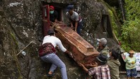 Sejumlah kerabat menurunkan jenazah keluarganya saat ritual Manene di Lembang Ampang Batu, Kabupaten Toraja Utara, Sulawesi Selatan. Mereka datang untuk membersihkan Patane yang terletak di Lembang (desa) Ampang Batu, Kecamatan Rinding Allo, Kabupaten Toraja Utara, Sulawesi Selatan.   