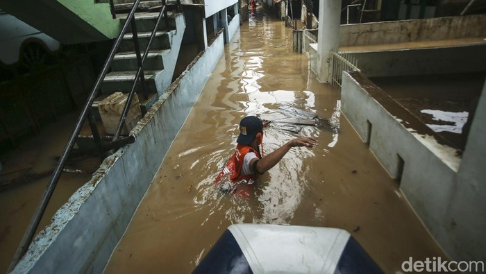 Sejumlah petugas PPSU memungut sampah saat banjir di Rawajati, Jakarta, Senin (10/10/2022). Banjir yang melanda kawasan ini juga turut membawa sampah ke pemukiman warga.