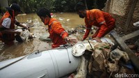 Pasukan Oranye bahu-membahu membersihkan sampah yang mengotori permukiman warga di Rawajati.