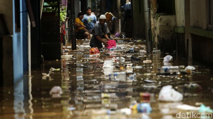 Sejumlah petugas PPSU memungut sampah saat banjir di Rawajati, Jakarta, Senin (10/10/2022). Banjir yang melanda kawasan ini juga turut membawa sampah ke pemukiman warga.