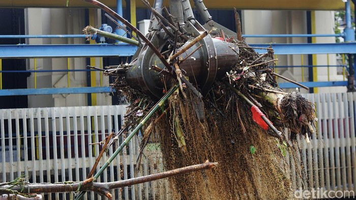 Petugas Dinas Kebersihan DKI Jakarta menggunakan alat berat untuk membersihkan sampah di Pintu Air Manggarai, Jakarta, Senin (10/10/2022). Hujan lebat yang mengguyur wilayah Bogor dan sekitarnya menyebabkan debit air Sungai Ciliwung meningkat dan menghanyutkan sampah ke Pintu Air Manggarai. 
Sebanyak 483 meter kubik atau sekitar 170,5 ton sampah berhasil diangkut petugas UPK Badan Air Manggarai, Jakarta Pusat dari Pintu Air Maggarai, Senin 10 Oktober 2022.