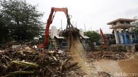 Petugas mengerahkan alat berat untuk membersihkan sampah di pintu air Manggarai, Jakarta, Senin (10/10/2022).