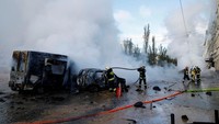Petugas pemadam kebakaran berupaya memadamkan api usai serangan rudal yang menyasar pusat kota Kyiv. REUTERS/Valentyn Ogirenko