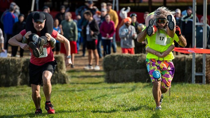 Serunya Lomba Menggendong Istri di Amerika, Nih Lihat Two teams compete during the 23rd North American Wife Carrying Championship at Sunday River Resort in Newry, Maine, on October 8, 2022. (Photo by Joseph Prezioso / AFP) (Photo by JOSEPH PREZIOSO/AFP via Getty Images)