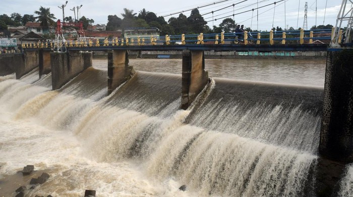 Pengendara motor melintas di atas jembatan Bendung Katulampa, Kota Bogor, Jawa Barat, Senin (10/10/2022). Tingginya intensitas curah hujan di kawasan Puncak dan Bogor pada Minggu (9/10/2022) menyebabkan debit air di Bendung Katulampa mengalami peningkatan yakni mencapai 220 cm atau siaga 1 banjir untuk warga yang berada di bantaran sungai Ciliwung. ANTARA FOTO/Arif Firmansyah/aww.