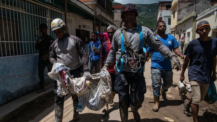 1243876379 LAS TEJERIAS, VENEZUELA - OCTOBER 10: (EDITORS NOTE: Image depicts death.) Recuers carry a toddler corpse after the rain-fueled landslide on October 10, 2022 in Las Tejerias, Venezuela. A landslide in central Venezuela killed at least 36 people and 56 remain missing since Sunday after heavy rains overflowed a ravine causing flash floods. (Photo by Carolina Cabral/Getty Images)