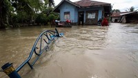 Warga berada di depan rumahnya yang diterjang banjir besar di Desa Mancang, Lhoksukon, Aceh Utara, Aceh, Senin (10/10/2022). Selain merendam jalan, banjir juga menggenangi beberapa perkantoran seperti Dinas Pendidikan, Dinas Sosial. Masyarakat di Lhoksukon disebut mulai mengungsi ke meunasah dan di sana juga dibuka dapur umum.  