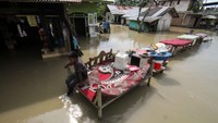 Seorang anak duduk di kursi depan rumahnya yang dikepung banjir besar di Desa Mancang, Lhoksukon, Aceh Utara, Aceh, Senin (10/10/2022). Banjir merendam puluhan desa yang terletak di 12 kecamatan di kawasan Aceh Utara. Banjir di sana terjadi sejak Rabu (5/9).  