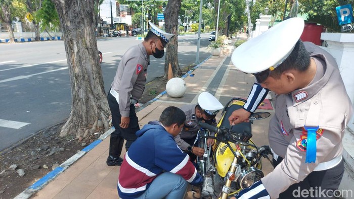 Anggota Satlantas Polres Probolinggo Kota bantu pasang spare part saat Operasi Zebra 2022