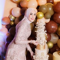 Kue ulang tahunnya pun tampak mewah dan elegan dengan beberapa tingkat dan dihiasi oleh bentuk-bentuk bunga. Sesuai dengan tema pesta ulang tahunnya, kue tersebut juga dibuat berwarna nude. Foto: Instagram/@erintaulany