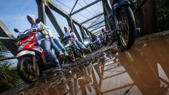 Sejumlah pengendara roda dua antre saat akan melintasi jembatan sementara di Sukajaya, Lebak, Banten, Selasa (11/10/2022). Bagian akses jembatan utama penghubung antarkecamatan tersebut rusak akibat diterjang banjir bandang pada Minggu (9/10/2022) sore. ANTARA FOTO/Muhammad Bagus Khoirunas/wsj.