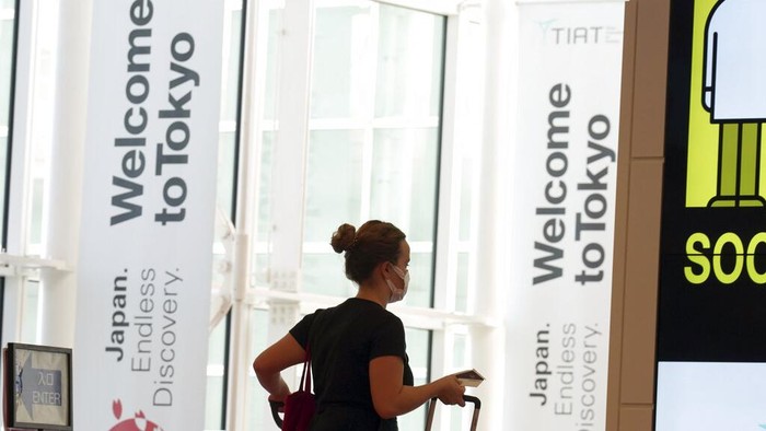 One of foreign travelers walks upon arrival at the Haneda Airport Tuesday, Oct. 11, 2022, in Tokyo. Japan's strict border restrictions are eased, allowing tourists to easily enter for the first time since the start of the COVID-19 pandemic. Independent tourists are again welcomed, not just those traveling with authorized groups. (AP Photo/Eugene Hoshiko)