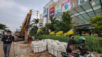 Trotoar lama dihancurkan menggunakan alat berat.