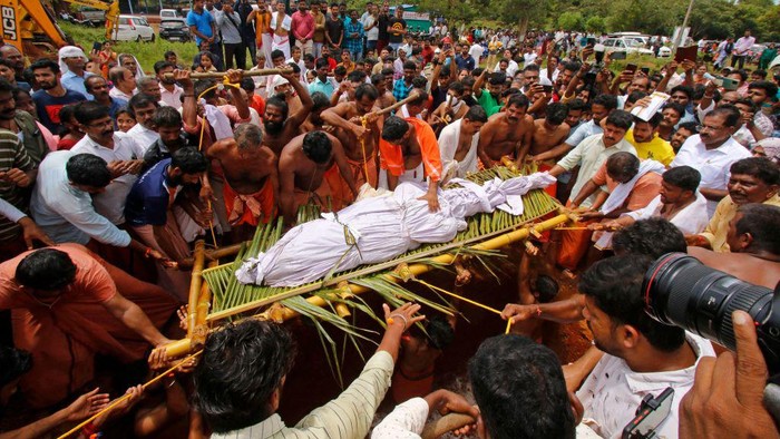 Pemakaman Buaya Suci di India Diiringi Tangis Warga People carry the dead body of Babia, a crocodile at Ananthapura lake temple, for its burial at the Ananthapadmanabha Swamy temple at Kasaragod in India's Kerala state on October 10, 2022. - Hundreds of people attended the tearful funeral on October 10 of a crocodile believed to have been divine and survived for decades on a vegetarian diet at a Hindu temple in India. (Photo by AFP) (Photo by -/AFP via Getty Images)