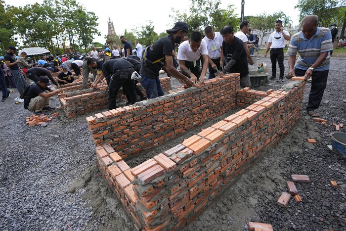Biksu Buddha mengawasi pembuatan tungku kremasi di kuil Wat Rat Samakee di Uthai Sawan, timur laut Thailand, Senin (10/10/2022) waktu setempat. Puluhan tungku ini dibangun untuk mengkremasi jazad para korban pembantaian di tempat penitipan anak yang terjadi pada Kamis (6/10).
