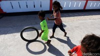 Anak-anak itu berlarian sambil menggelindingkan ban bekas di jalanan Desa Fursui, Pulau Selaru, Kabupaten Kepualaun Tanimbar.