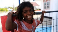 Salah seorang anak tersenyum bahagia di sela-sela bermain dengan teman-temannya.